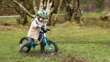 boy riding through the forest on a littlebig 14 inch balance bike