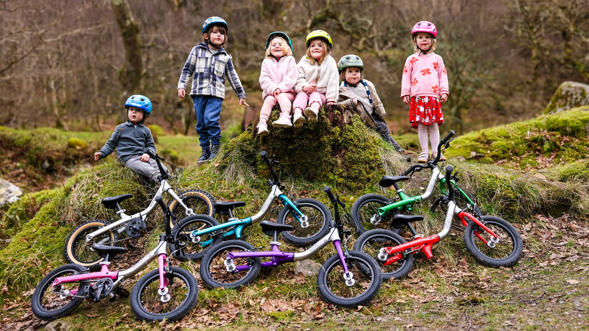 Children with balance bikes in a natural setting